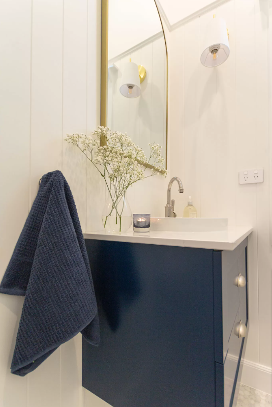 Blue and gold accent features in a white bathroom renovation in Mosman